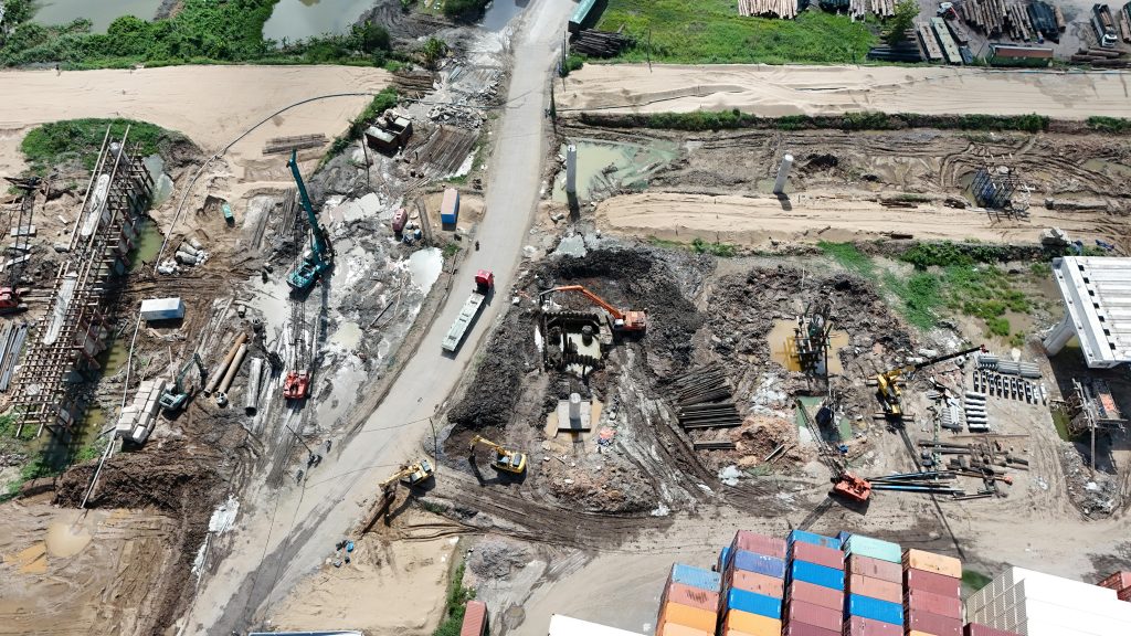 Aerial view of a busy construction site with heavy machinery and containers.